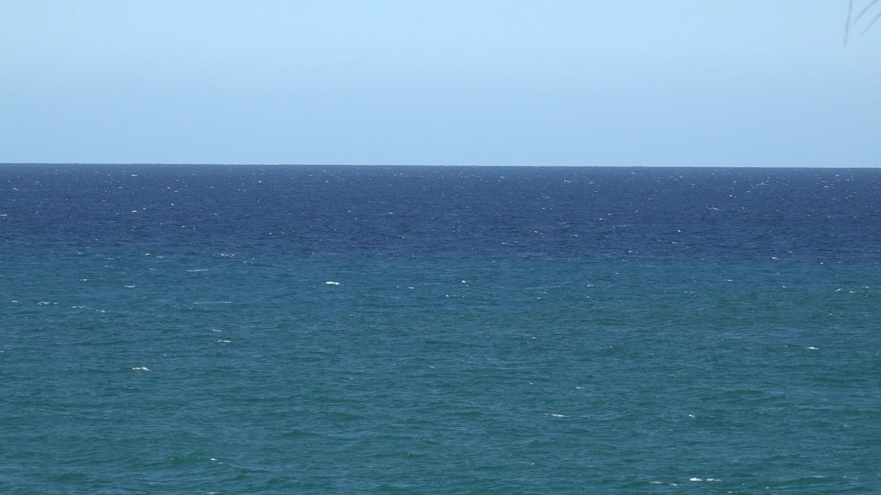 A second view holds on the straight horizon as darker blue water shifts into teal foreground ripples, with no visible people.