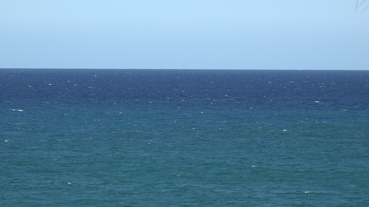 Blue-green ocean horizon under a pale blue sky.