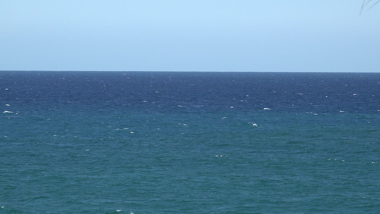 Opening frame of blue water and pale sky from the Grand Junction, Colorado 2017 clip, with small white ripples on the surface and no visible people.