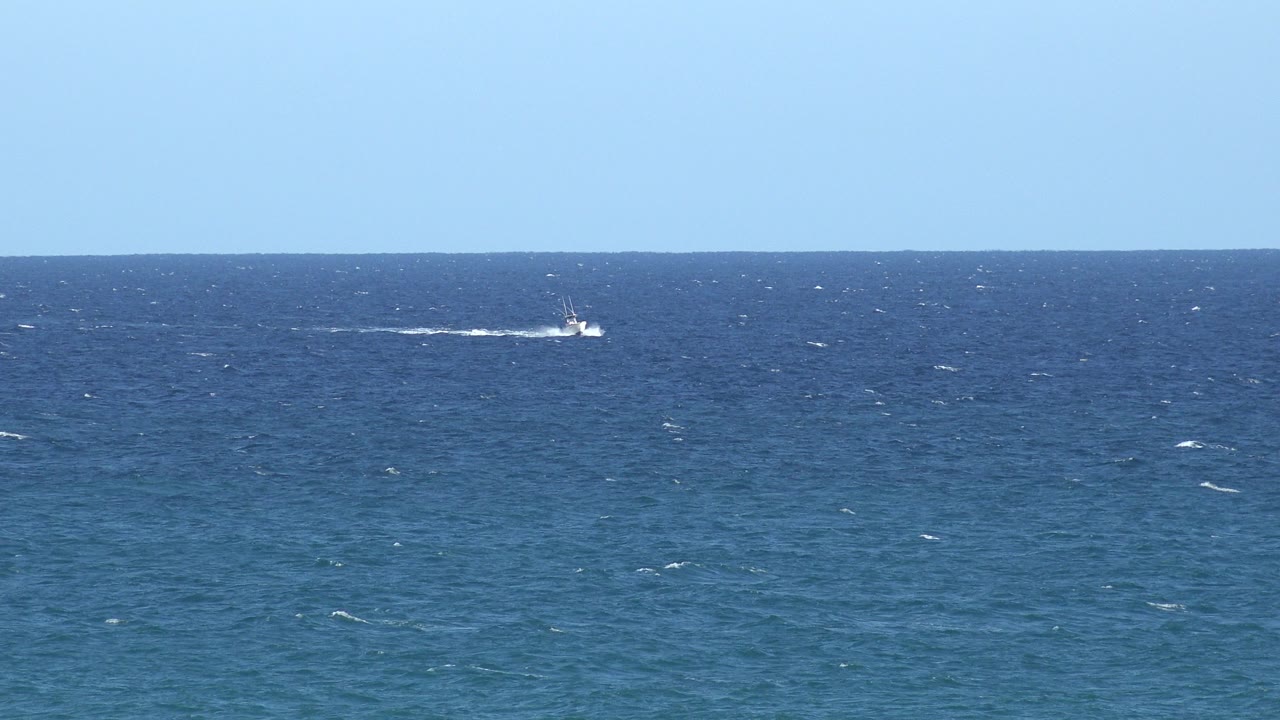 Wide blue ocean horizon in the Grand Junction, Colorado 2017 collection, with small distant boat wakes on choppy water and no visible people.