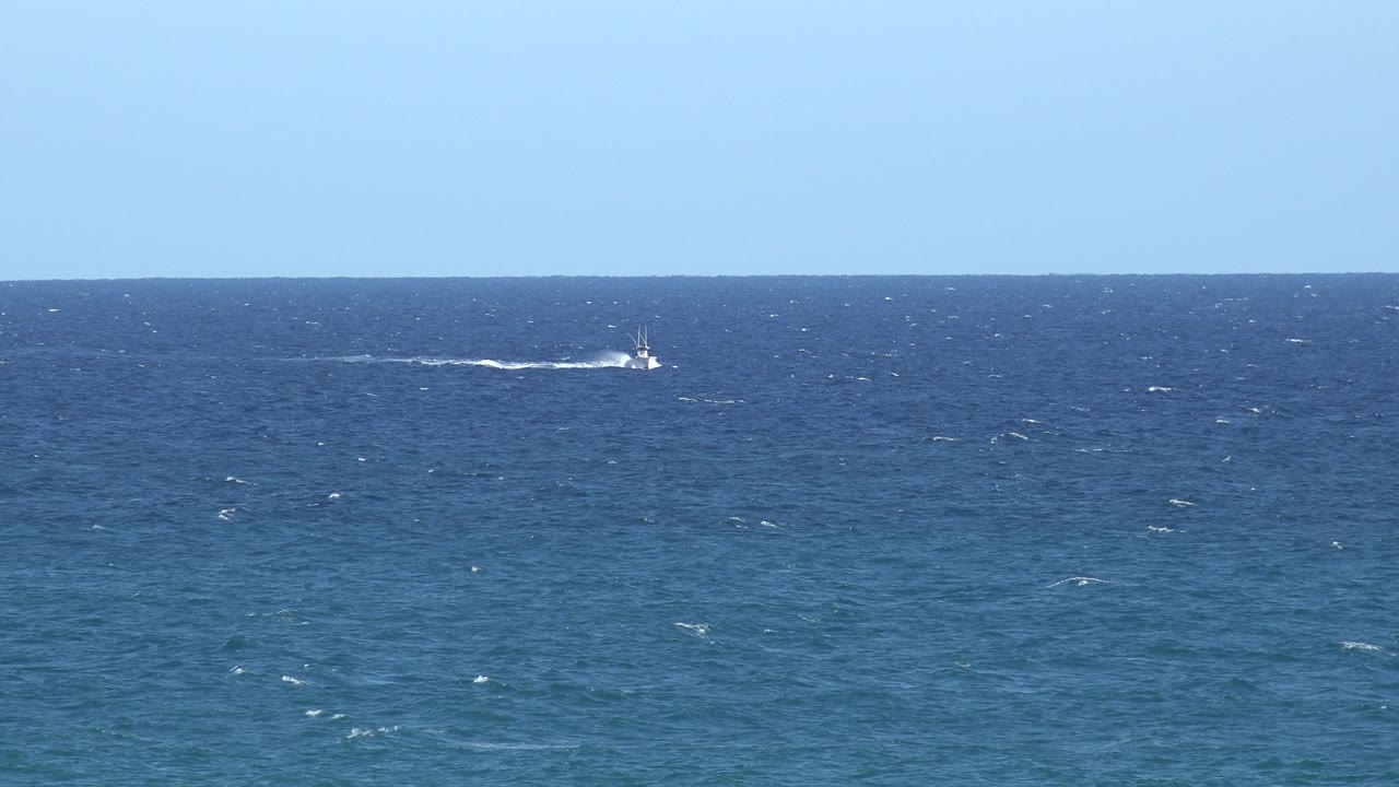 Choppy sea with distant boat activity