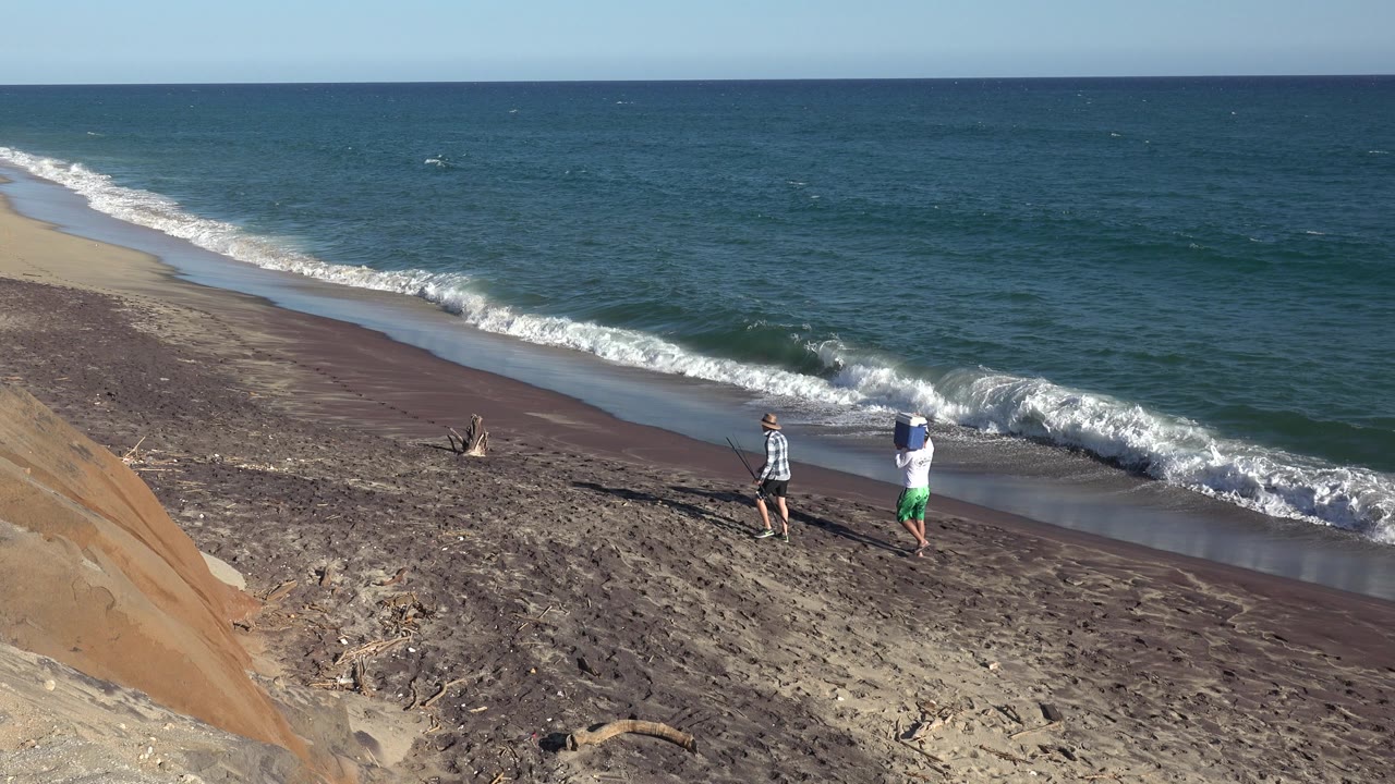 At one second, the two people remain near the waterline on the Grand Junction, Colorado beach as a white wave rolls toward the darker strip of wet sand.