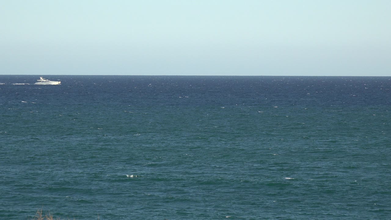 Wide blue-green water and pale sky in the Grand Junction, Colorado 2017 clip, with a small white boat near the left horizon and no visible people.
