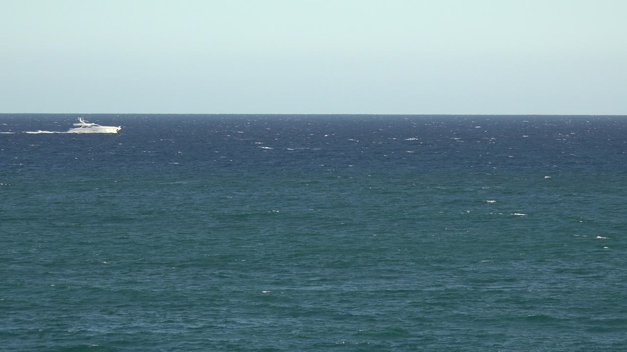 A white passenger ship appears farther along the horizon in the Grand Junction Colorado 2017 footage, with textured blue water below and no visible people.