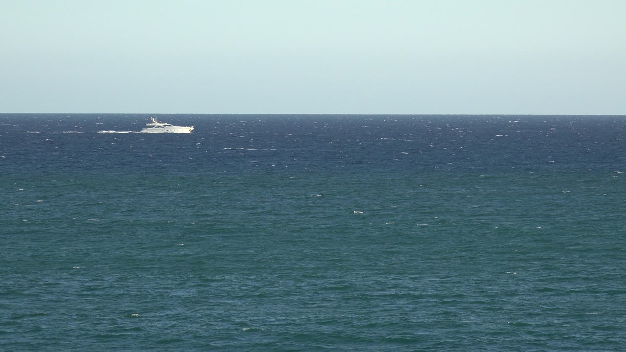 A distant white ship sits near the left side of a blue ocean horizon in the Grand Junction Colorado 2017 clip, with whitecaps on the water and no visible people.