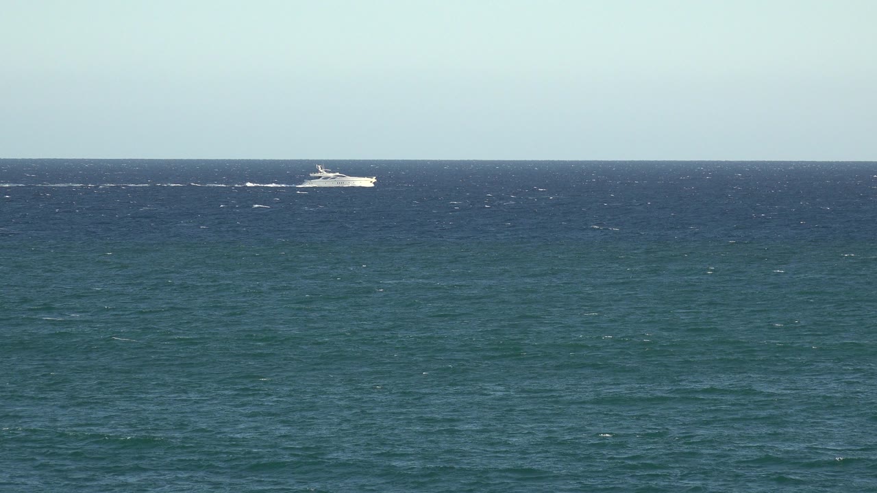 Distant white boat sits closer to the center of the horizon over textured blue water in this Grand Junction, Colorado 2017 clip frame, with no visible people.