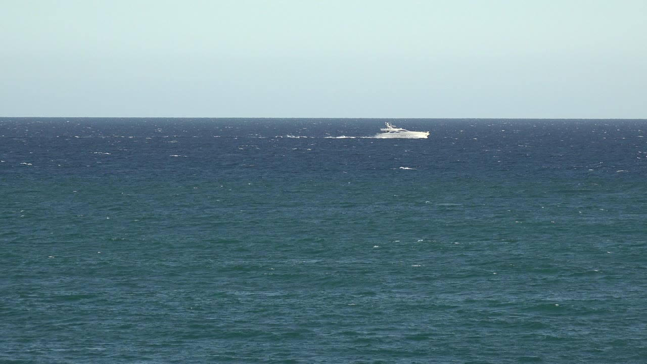 At 0:00, a distant white boat crosses the dark blue ocean horizon in the Grand Junction Colorado 2017 clip, with pale sky above and no visible people.