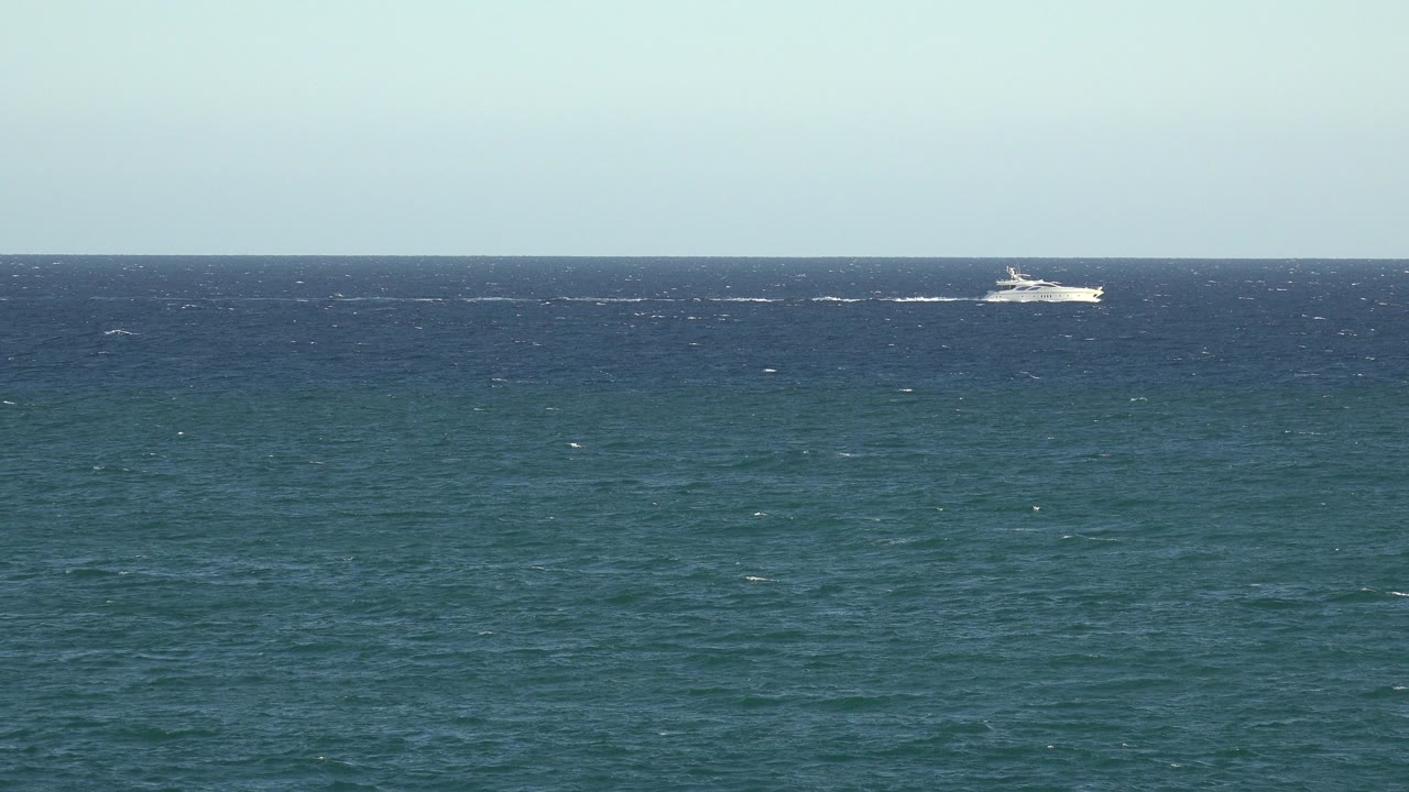 Second frame from the Grand Junction, Colorado 2017 beach clip with the white boat slightly farther across the horizon line and no visible people.