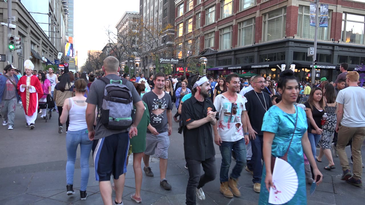 Costumed and casual pedestrians fill a downtown street