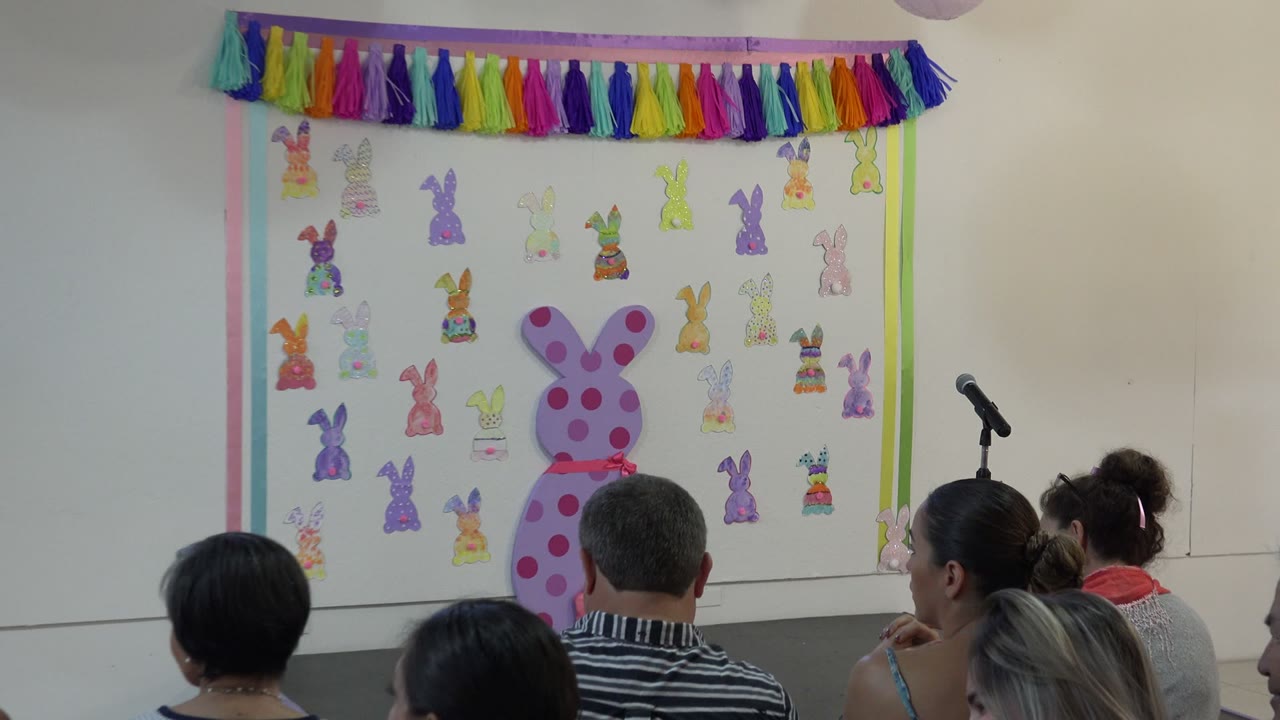 Decorated school stage with seated audience facing bunny artwork.
