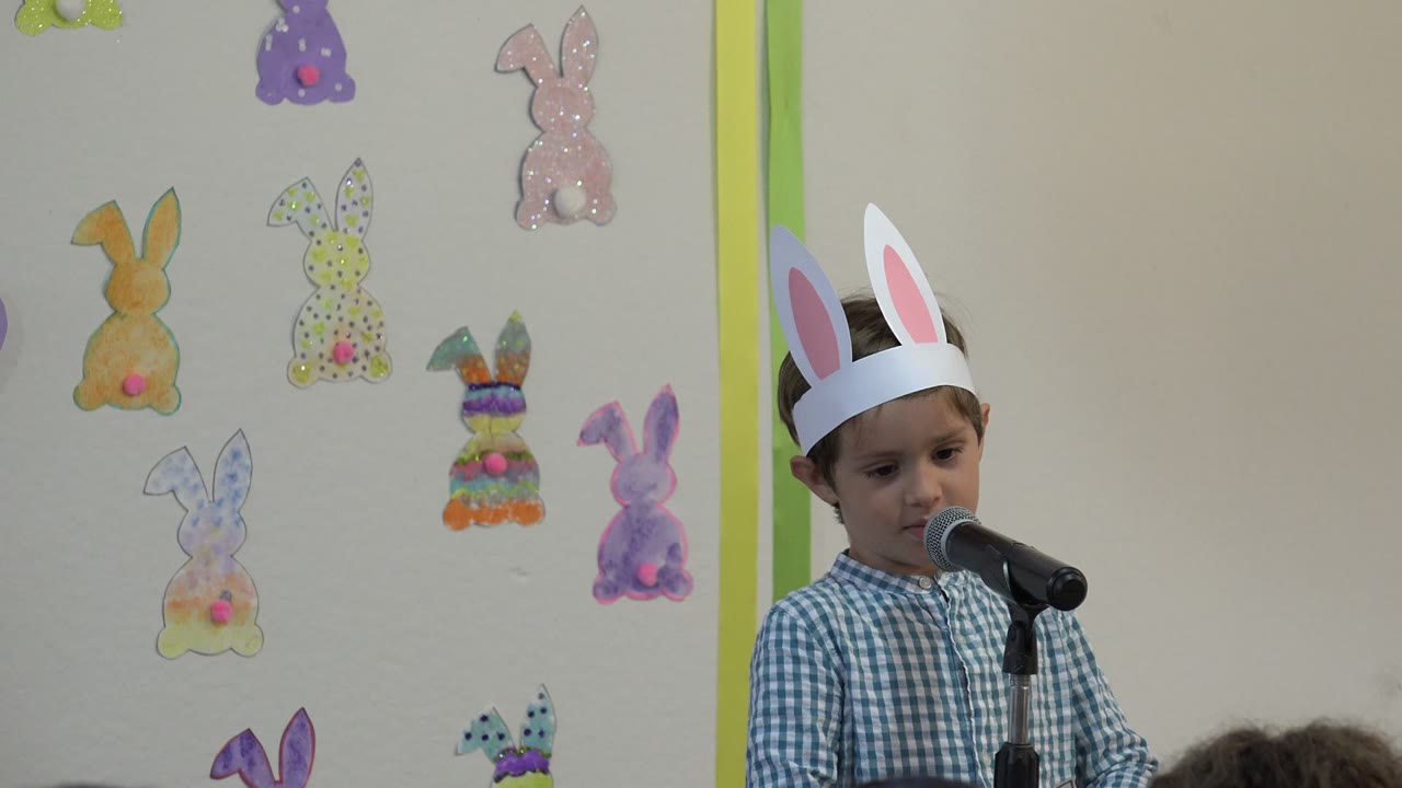 Boy in rabbit-ear headband speaking into a microphone