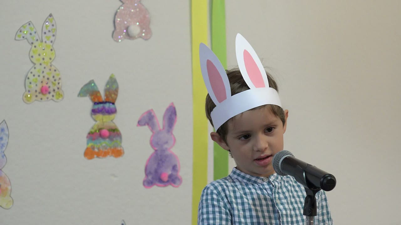 One second in, the boy in Cabo San Lucas looks toward the microphone while pastel bunny cutouts remain visible across the wall behind him.