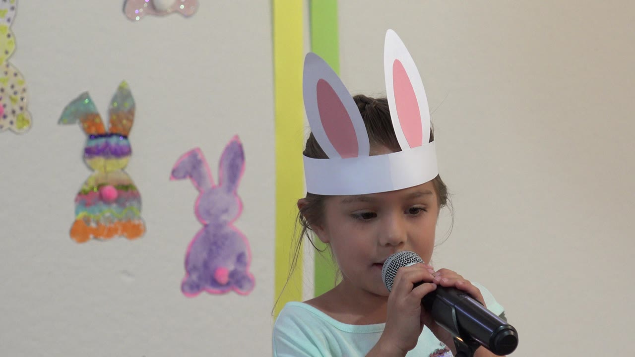 Child looks down slightly while speaking into the microphone.