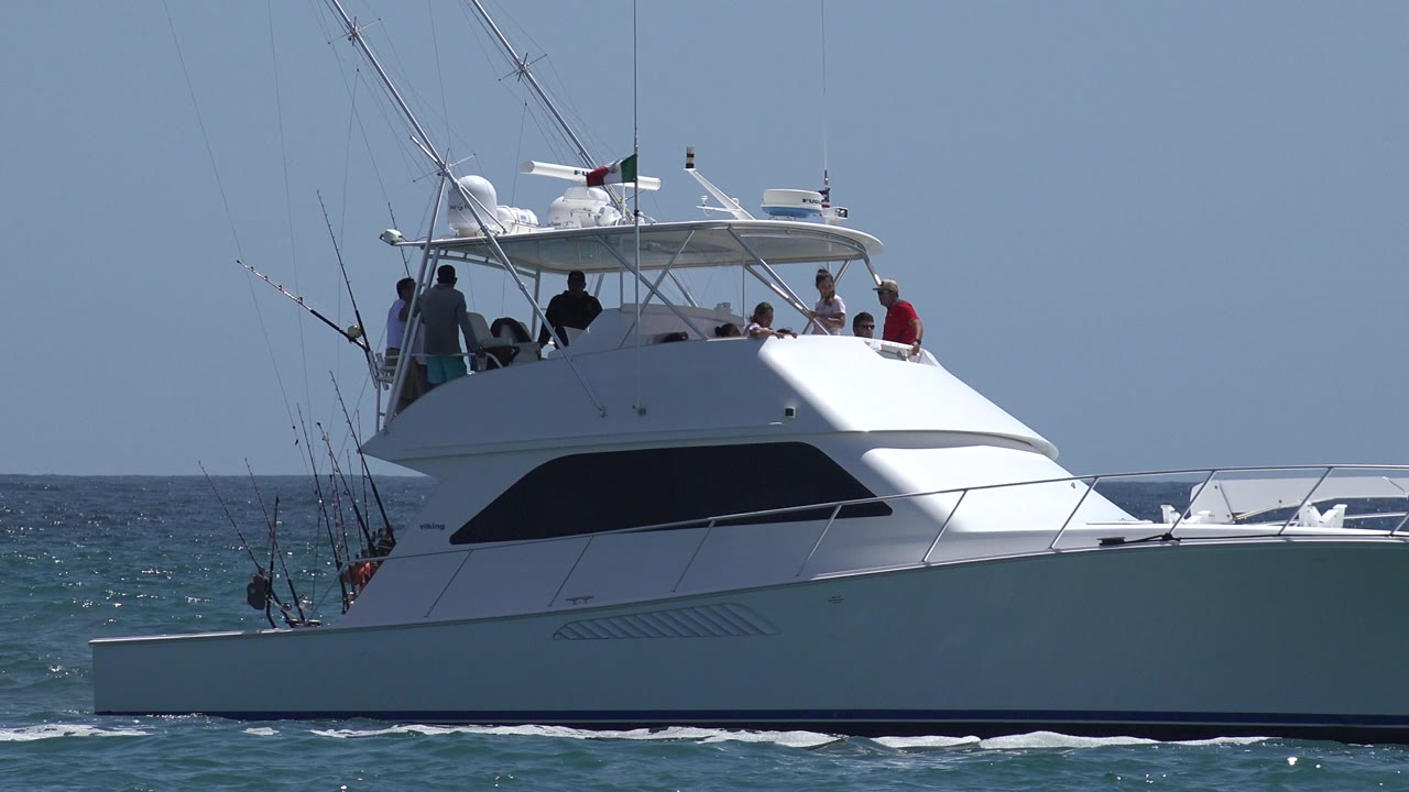 Sport fishing boat with people on deck and rods at the stern.