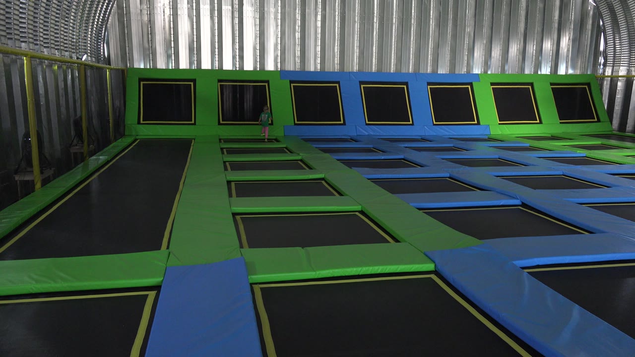 Empty trampoline area with green and blue mats