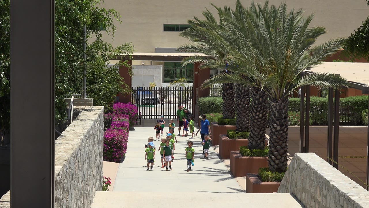 Children and adults walking on a landscaped outdoor path.