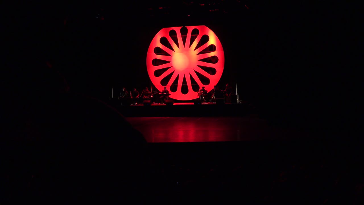 Dark stage with a glowing red circular set piece.