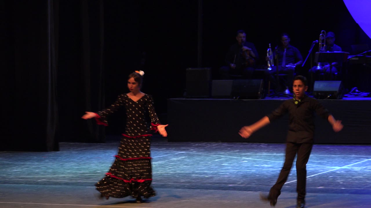 Female dancer in black and red dress and male dancer on stage