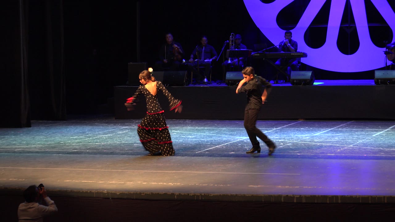 Two young dancers move apart during a stage routine.