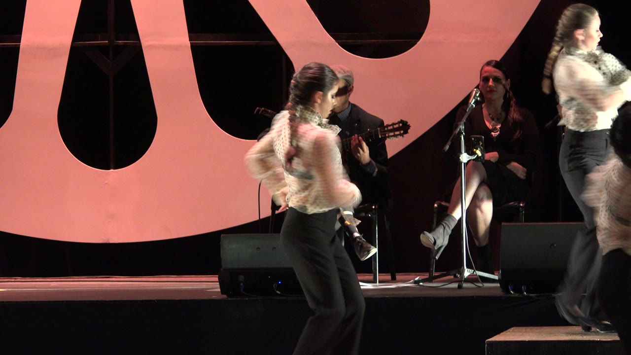 Dancers on a stage with musicians behind them