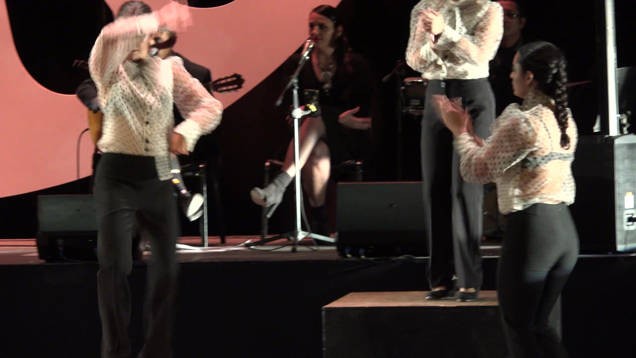Woman dancing on a wooden box during a stage performance.