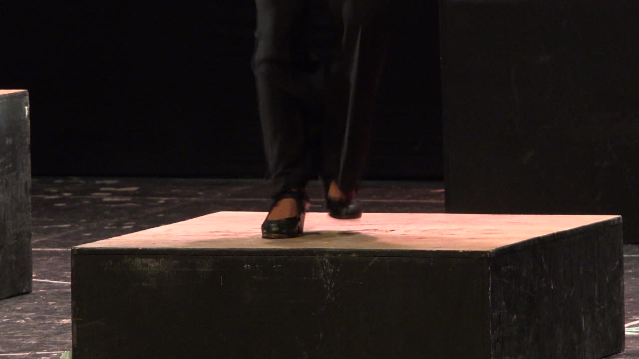 Dancer's feet land close together on the stage platform.