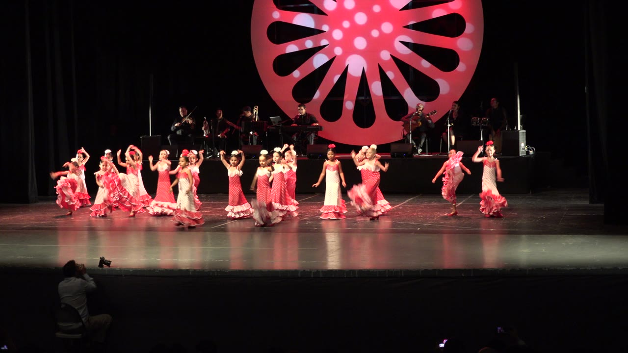 Children raising arms during a stage dance routine