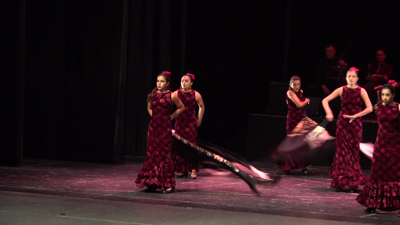 Two front dancers face forward while others move behind them.