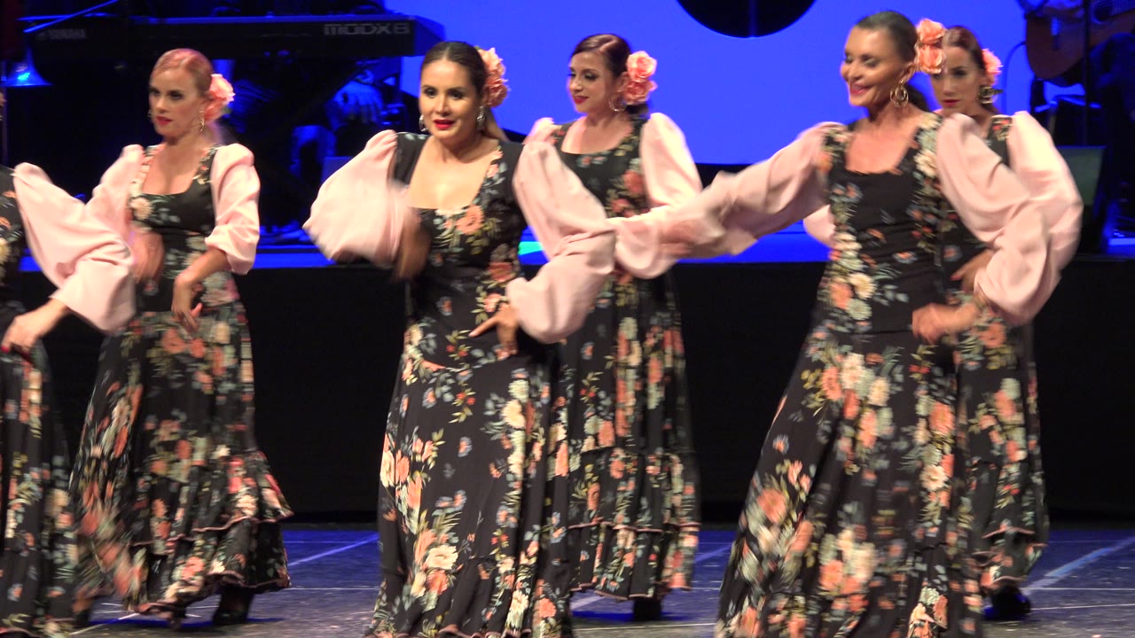 Women dance with skirts swirling on stage.