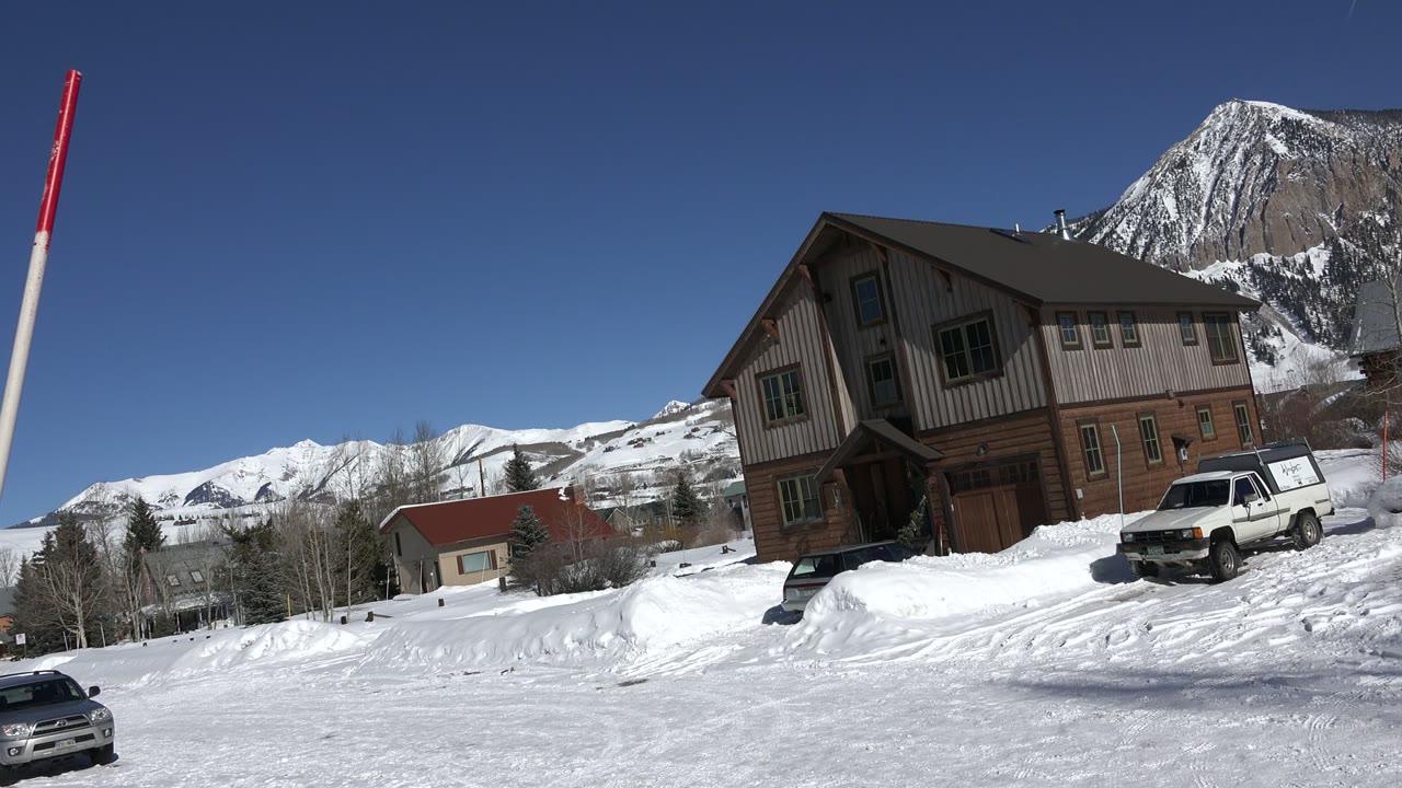 Snowy Crested Butte building with mountain ridge behind it