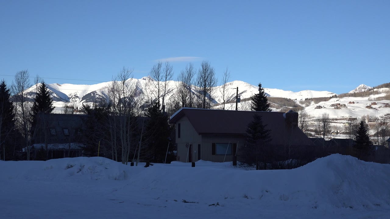 Second frame shows the Crested Butte house still in deep foreground shadow, with bright snow-covered mountains and no visible people.