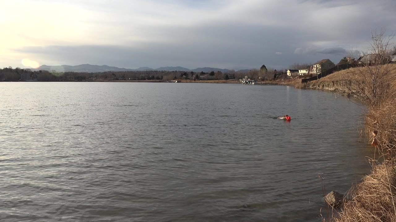 Wide lake with a small red object near the right shore