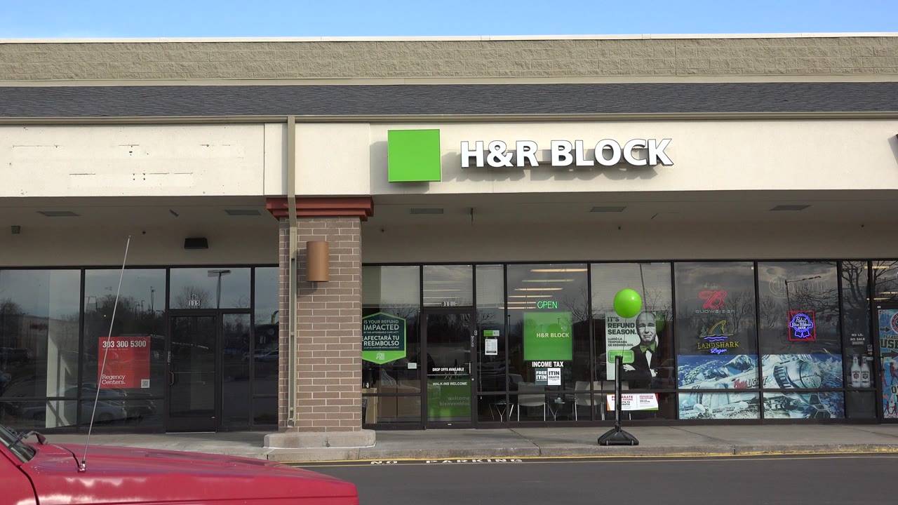 H&R Block storefront with green balloon and red pickup hood.