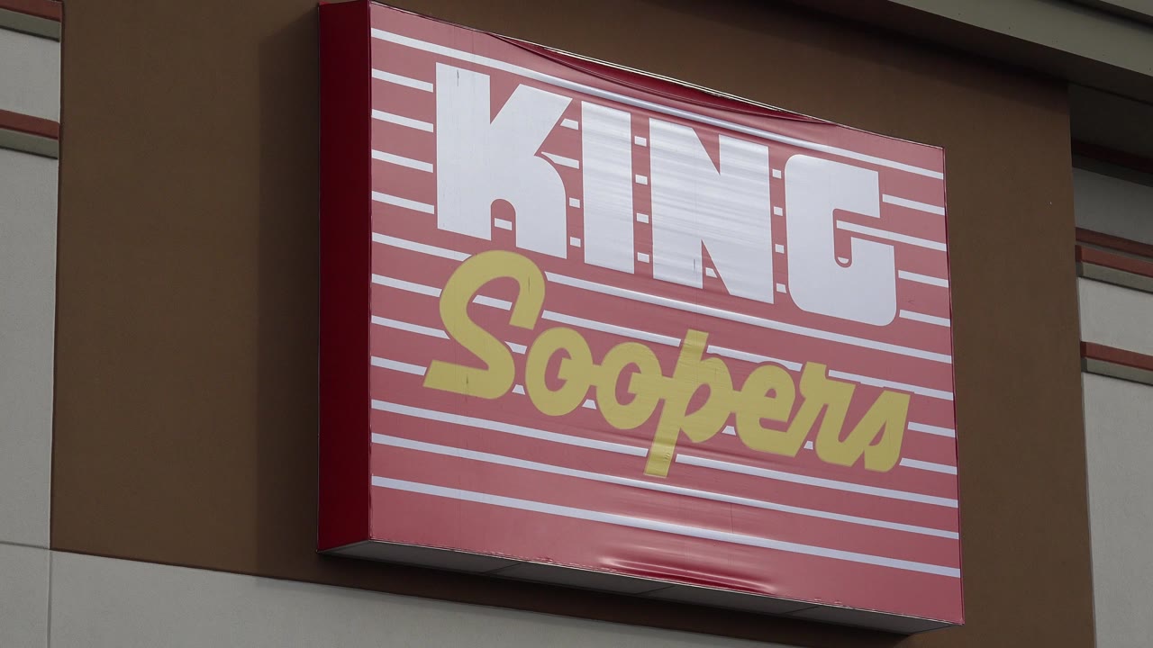 Close view of a red King Soopers sign on a storefront wall.