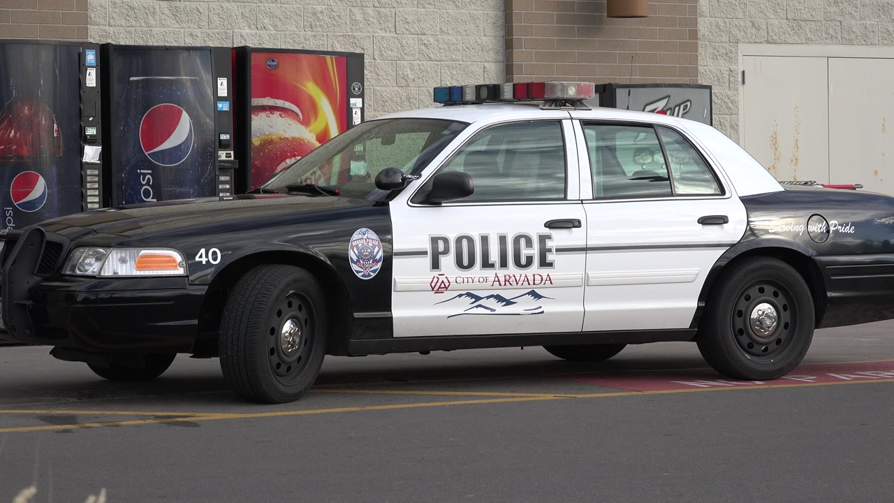 Black and white police car parked beside vending machines