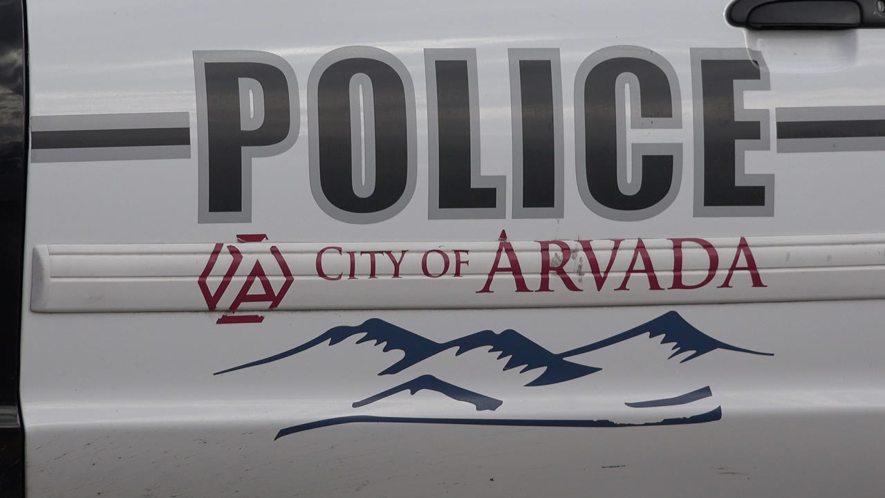 Close view of a white police vehicle door with City of Arvada text