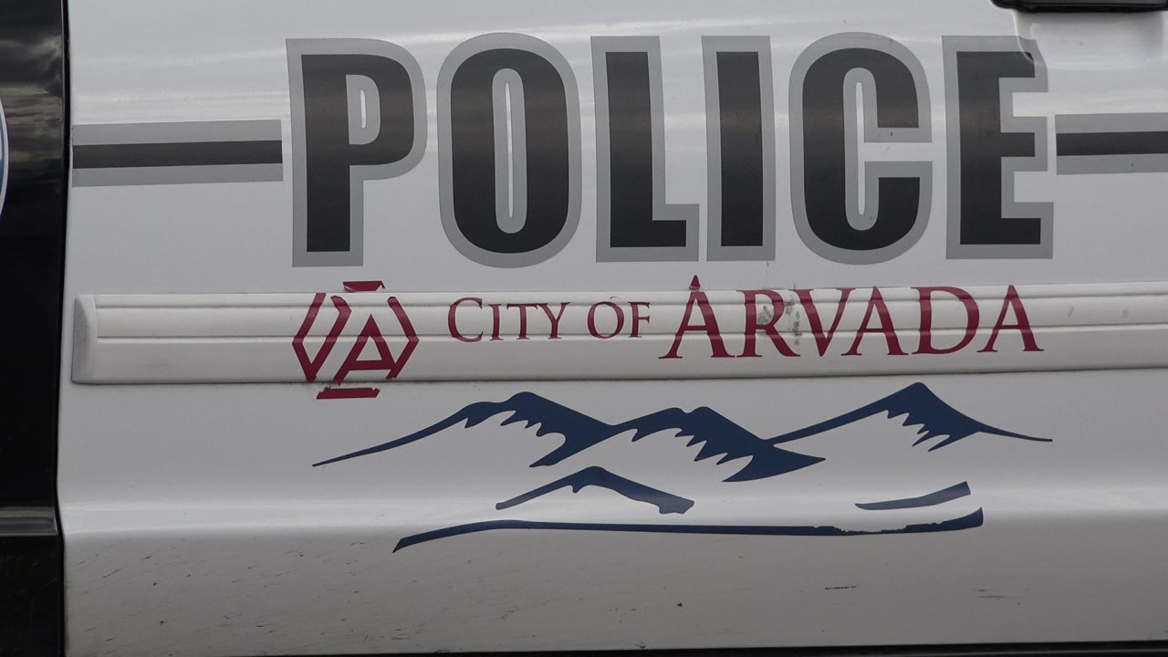 Close view of a marked police car door with City of Arvada text