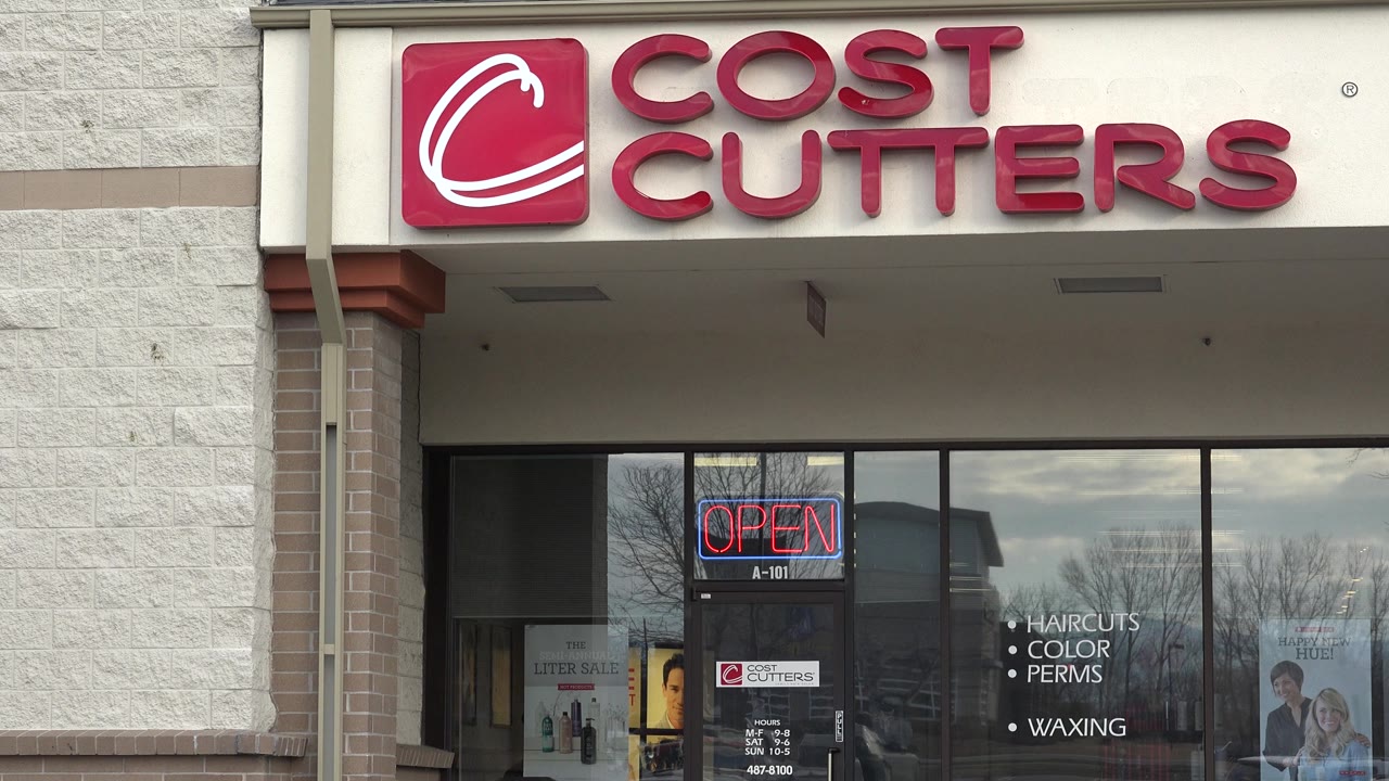 Cost Cutters storefront with red sign and open neon in the window.