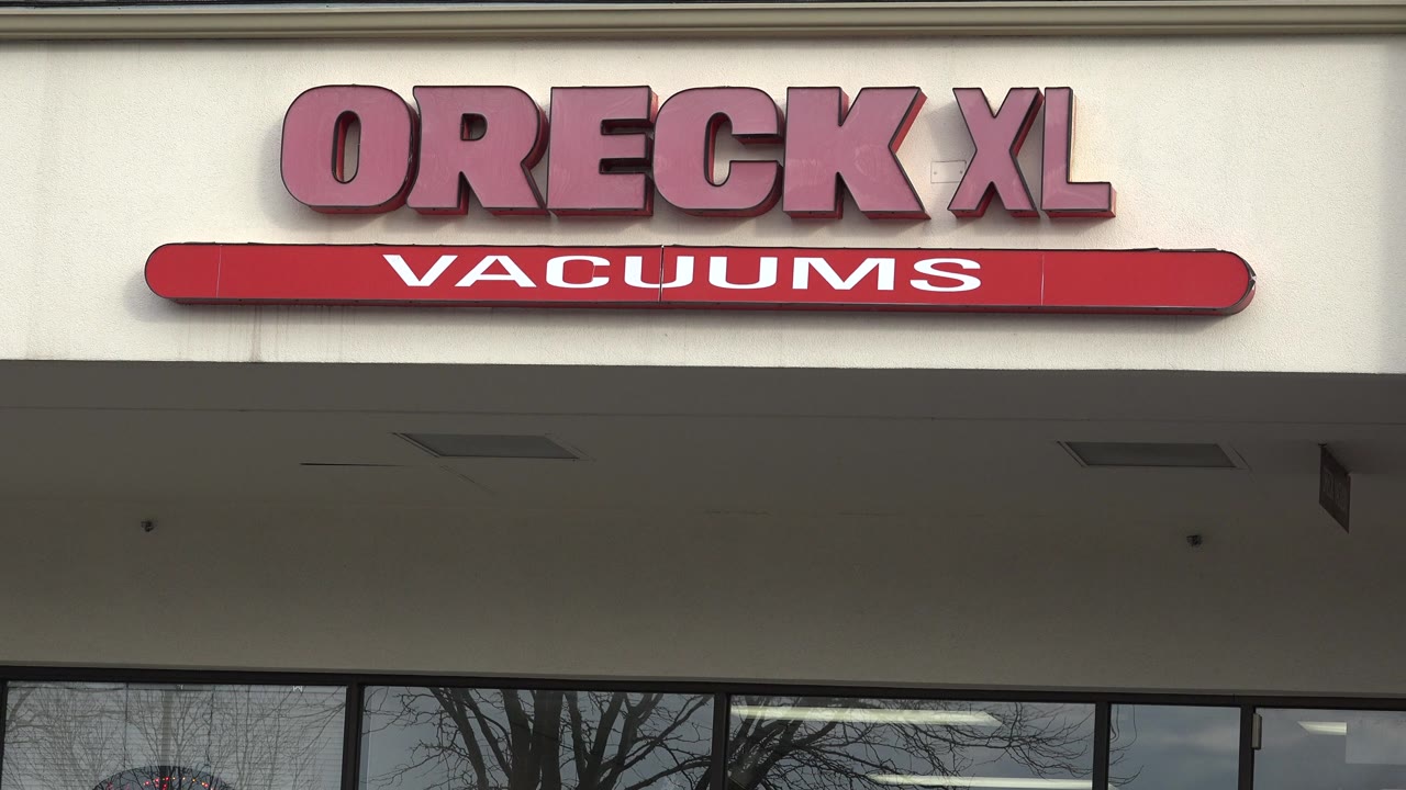 Close view of Oreck XL Vacuums signage above storefront windows.