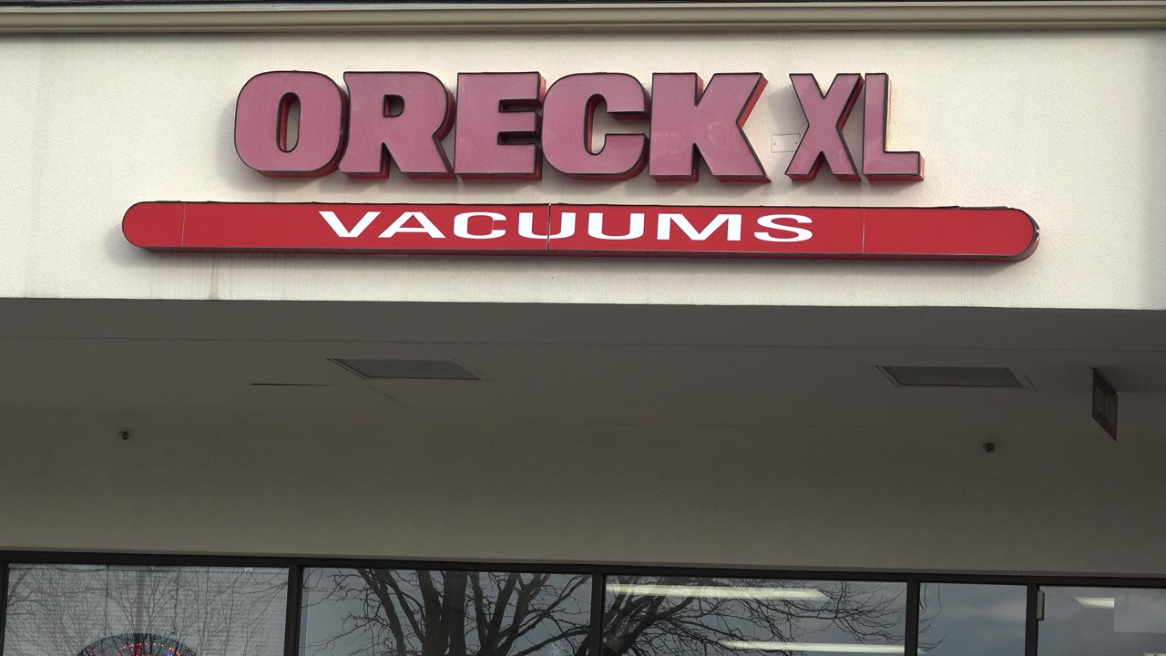 Westminster, Colorado retail facade with the Oreck XL Vacuums sign slightly lower in frame and window reflections below, with no visible people.