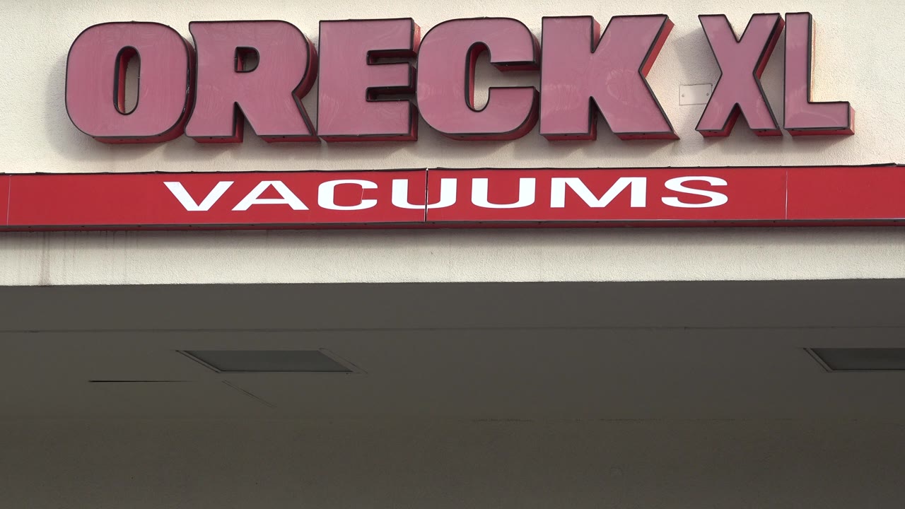 A centered view holds on the Oreck XL letters and red Vacuums bar across the storefront fascia in Westminster, Colorado, with no visible people.