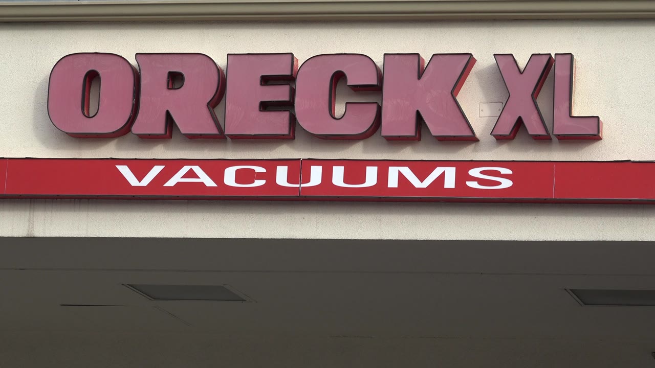 The Oreck XL letters sit above the red VACUUMS fascia on the Westminster storefront, with the overhang filling the lower half and no visible people.