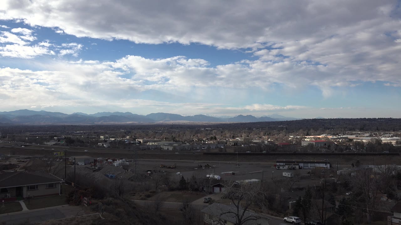 Cloudy sky over town buildings and distant mountains