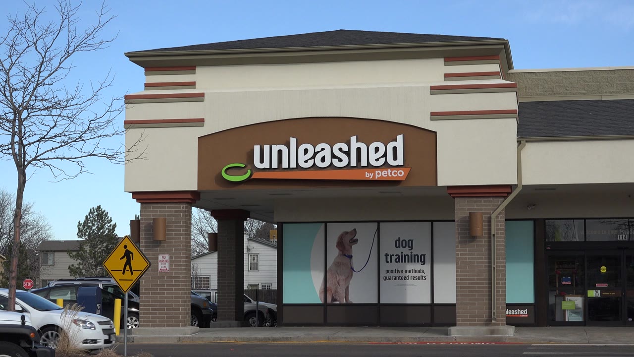 Unleashed by Petco storefront beside a pedestrian crossing sign.