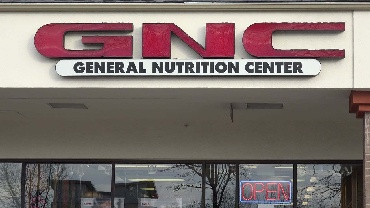 GNC General Nutrition Center storefront in Westminster, Colorado, with red signage, glass windows, and an open sign visible, no visible people in this frame.