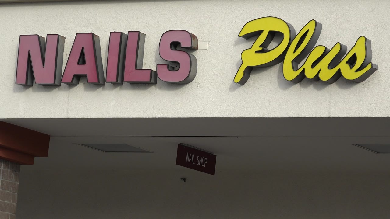 Close view of NAILS Plus storefront lettering.