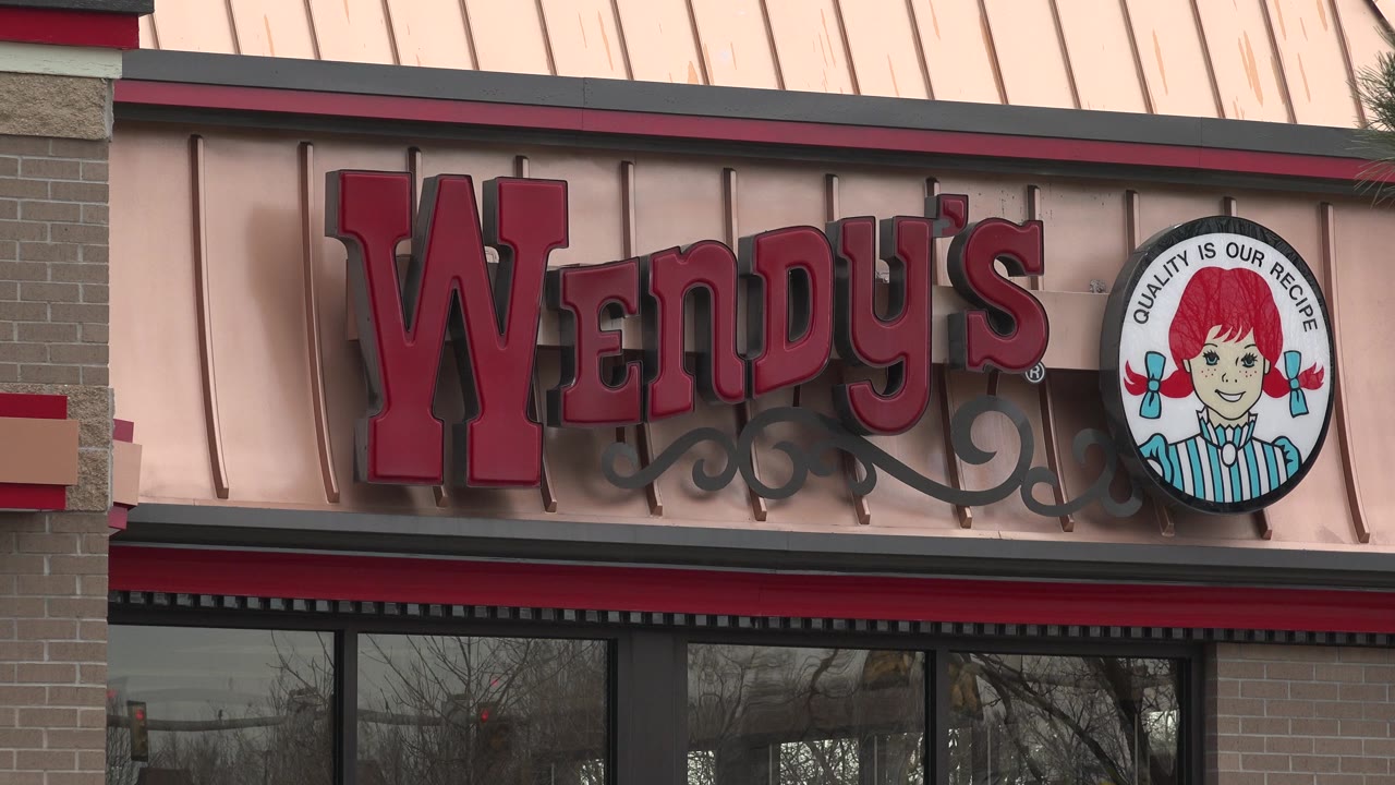 Close view of a Wendy's storefront sign on a brick restaurant facade.