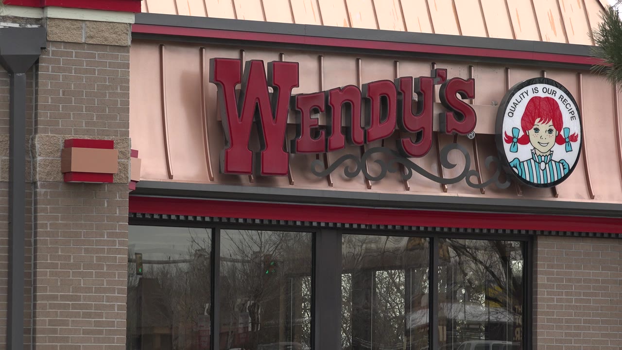 Wendy's restaurant sign above dark windows on a brick facade.