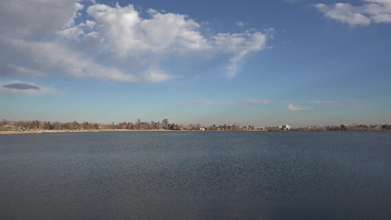Open water and low shoreline beneath bright clouds.