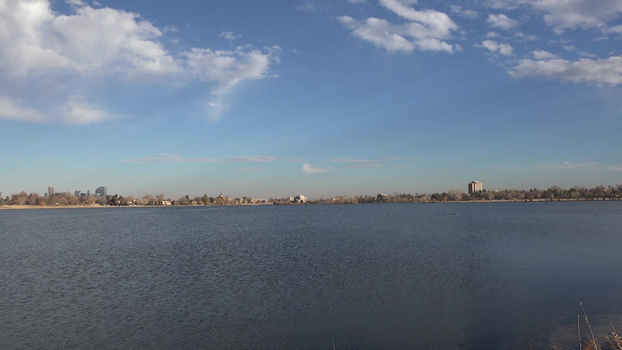 Low shoreline across water with clouds high in the sky